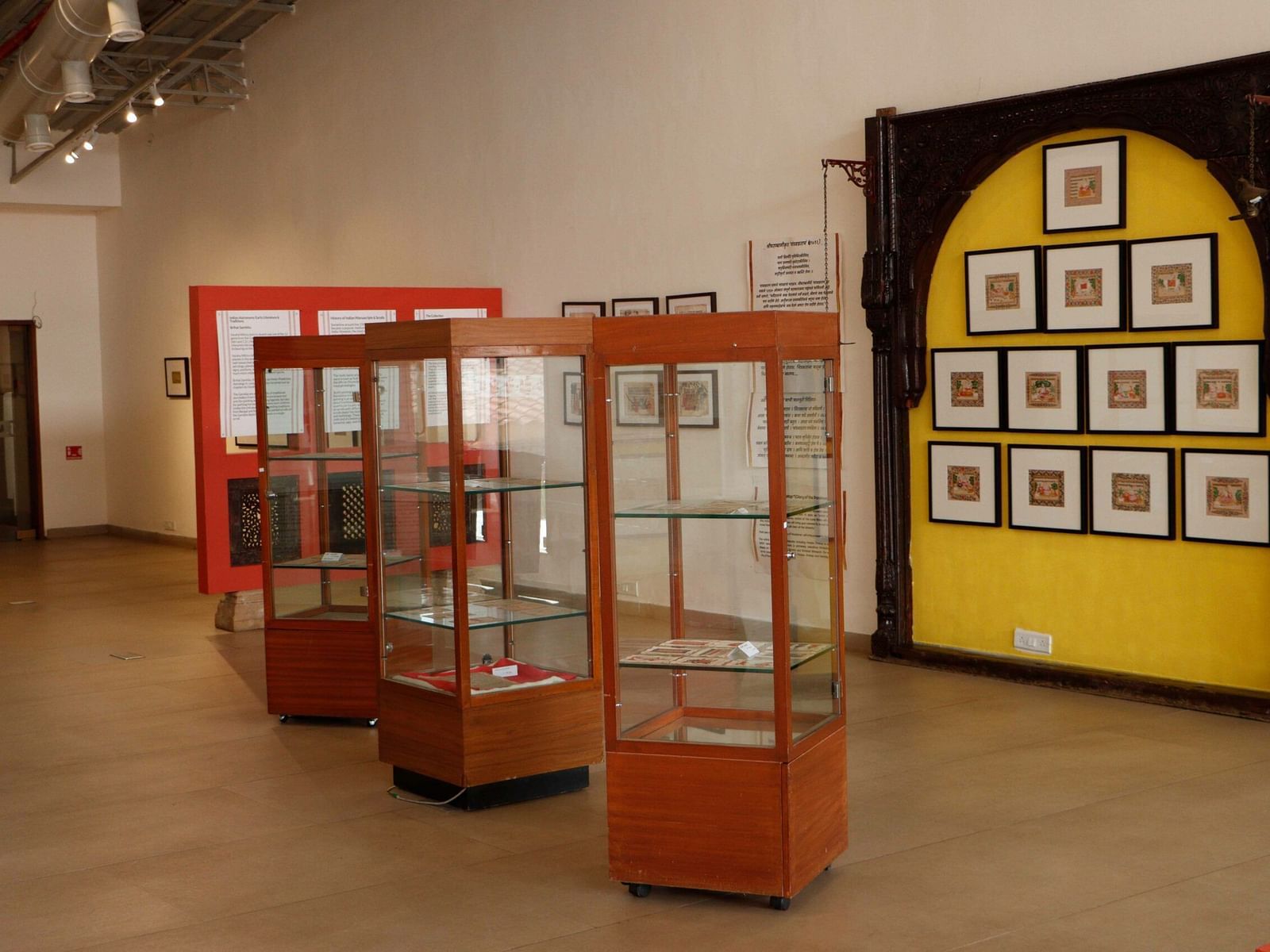 A gallery inside the Zapurza Museum of Art & Culture.  Several display cases showcase various artifacts and artworks, and a wall is adorned with a collection of framed paintings.